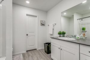 een witte badkamer met een wastafel en een spiegel bij Spacious 4BR Family Home in New Braunfels in New Braunfels