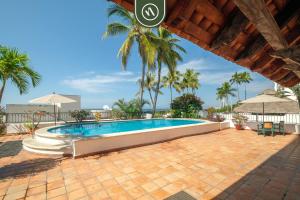 a swimming pool in a resort with palm trees at Amazing 2 BR Condo - Private Terrace - Pool in Puerto Vallarta