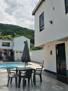 a table with an umbrella next to a pool at Narv extrema in Utica +19 photos