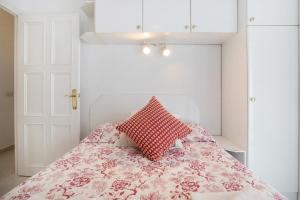 een slaapkamer met een bed met een rood kussen erop bij Prealsa Benalmádena in Benalmádena +18 foto's