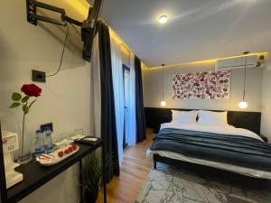 a bedroom with a bed and a table with a flower on the wall at XIX Boutique in Skopje