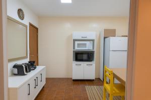 a kitchen with a refrigerator and a microwave at LSViver Hospedagem in Caxias do Sul