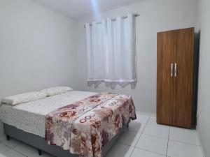 维多利亚-达孔基斯塔Apartamento Térreo Com Portaria 24h的带床和木柜的卧室