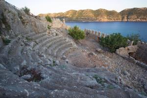 ein antikes Amphitheater auf einem Hügel neben einem See in der Unterkunft Cennet Pansiyon in Kaleucagız + 23 Fotos