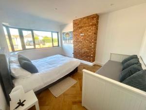 a bedroom with a bed and a brick wall at The Crescent Villa Lancing in Lancing