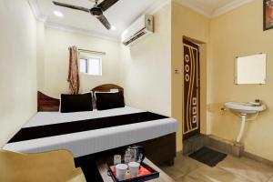 a hotel room with a bed and a sink and a toilet at Hotel O Sri Sai Mani Lodge in Vijayawāda