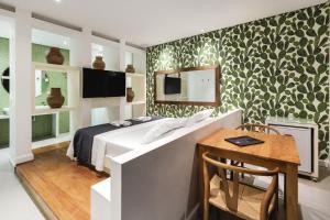a bedroom with a bed and a table and a tv at Motel Acaso (Adults Only) in São Paulo