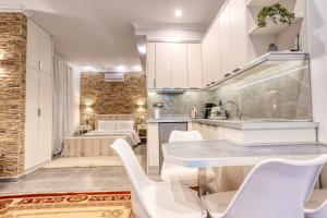 トリカラにあるWhite Houseの白いキャビネットとテーブルと椅子のあるキッチン +36枚の写真