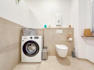 a bathroom with a washing machine and a toilet at Eifelleben Hillesheim in Hillesheim