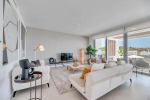 ein Wohnzimmer mit weißen Möbeln und einem großen Fenster in der Unterkunft Villa Riva in Marbella