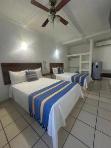 Una habitación de hotel con dos camas y un ventilador de techo. en Hotel Careyes Puerto Escondido, en Puerto Escondido 59 fotos más