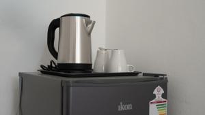 a coffee pot and cups on top of a microwave at بيت الشّاب in Ţīwī