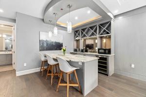 a kitchen with a large island with white chairs at Family guest suite in Marpole in Vancouver