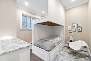 a white bedroom with a bed and a window at Family guest suite in Marpole in Vancouver