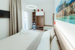 a bedroom with a bed and a painting on the wall at Verga 16 Deluxe Cefalù Apartments in Cefalù +31 photos