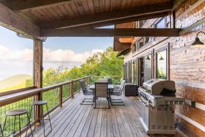 a deck with a grill and tables and chairs at Above and Beyond in Boone