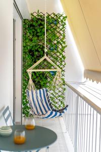 een hangmat die aan een balkon hangt met een groene muur bij Stylish Luxury Getaway 3BR Apartment 115m in Athene