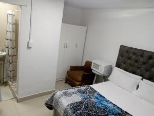 een hotelkamer met een bed en een stoel bij The trout Lodge in Kaapstad