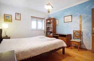 a bedroom with a bed and a book shelf at Casa da Mãe Maria in Buarcos