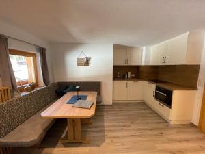 a kitchen with a wooden table and a couch at Apartment Bergglück Wildschönau in Wildschönau