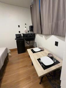 a small room with a table and a desk at 3Kitnet nova ao lado de tudo que você precisa in Lavras
