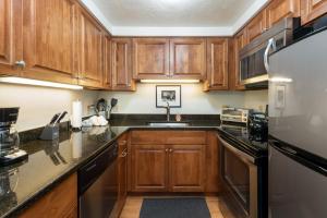 ベールにあるChristiania Condominiums- CoralTree Residence Collectionのキッチン(木製キャビネット、冷蔵庫付)