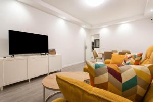 a living room with couches and a flat screen tv at Obsidian Aquarela Costa Adeje in Adeje