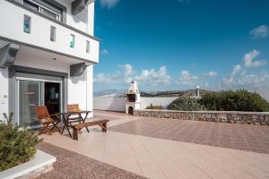 a patio with a table and chairs and a lighthouse at White Pearl Apolakkia 2 in Apolakkiá