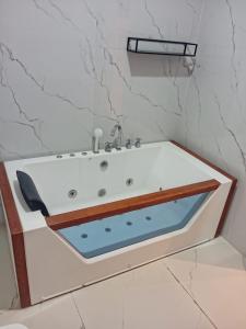 a bathroom with a bath tub with a sink at Viva Hôtel Ouaga 2000 in Ouagadougou