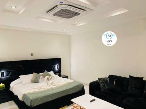 a bedroom with a bed and a couch at Viva Hôtel Ouaga 2000 in Ouagadougou