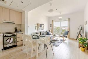 a kitchen and living room with a table and chairs at F1 - A Place to Stay 1BR Waters Edge Yas Island - Theme Parks in Abu Dhabi