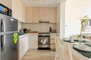 a kitchen with a table and a stove top oven at F1 - A Place to Stay 1BR Waters Edge Yas Island - Theme Parks in Abu Dhabi +18 photos