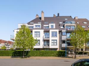 ein großes Apartmenthaus mit Bäumen davor in der Unterkunft Aan Zee in Galopen