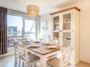 ein Esszimmer mit Tisch und Stühlen und einem Fenster in der Unterkunft Aan Zee in Galopen + 16 Fotos