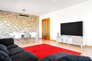 a living room with a couch and a flat screen tv at La Plana in Creixell