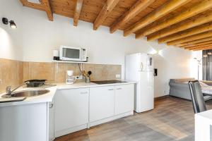 Una cocina con gabinetes blancos y un refrigerador blanco. en Appartement entre campagne et océan, en Breuil-Magné 13 fotos más