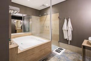 Un baño con bañera grande y ducha. en Motel Acaso (Adults Only), en São Paulo