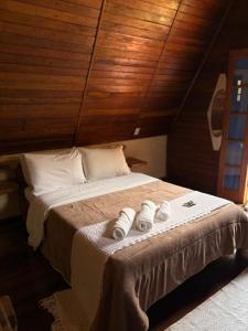 a bedroom with a bed with two towels on it at Pousada Cabanas do Visconde in Visconde De Maua +12 photos