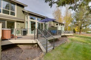 une maison avec une terrasse couverte et un parasol dans l'établissement Eagle Crest Retreat Creekside Townhome with Hot Tub, à Redmond