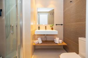 a bathroom with a sink and a mirror and a shower at Brabo Apartments in Hospitalet de Llobregat +44 photos