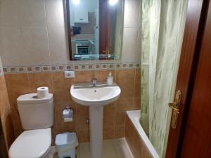 een badkamer met een wastafel, een toilet en een spiegel bij Vivienda vistas bonitas in Calera