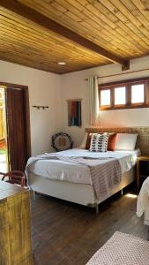 a bedroom with a large bed with a wooden ceiling at Estação Orgânica Taipu in Marau +35 photos