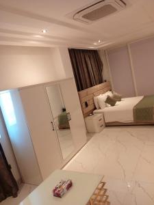 a small bedroom with a bed and a mirror at Viva Hôtel Ouaga 2000 in Ouagadougou +8 photos