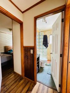 Un baño con inodoro y una cama y una puerta. en Casa, en Punta Arenas