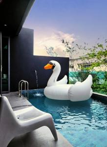 a pool with an inflatable swan in the water at Cyberjaya Puchong JWJ Pool Villa in Cyberjaya