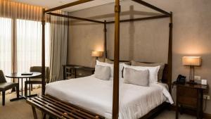 - une chambre avec un lit à baldaquin, une table et des chaises dans l'établissement Pueblo Nativo Resort Golf & Spa All Inclusive, à La Cumbre