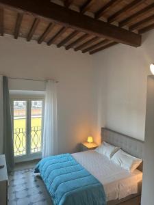 a bedroom with a blue bed and a window at Lungarno Suite in Pisa +16 photos