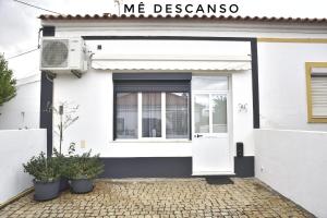 a white house with a white door and a window at O mê descanso in Vimieiro