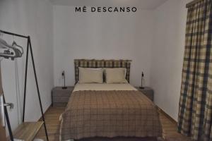a bedroom with a bed with two night stands and two tables at O mê descanso in Vimieiro