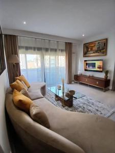 a large living room with a couch and a tv at Bayt Nour - Alger Riyadh City Oued El Moussa in Ouled Moussa